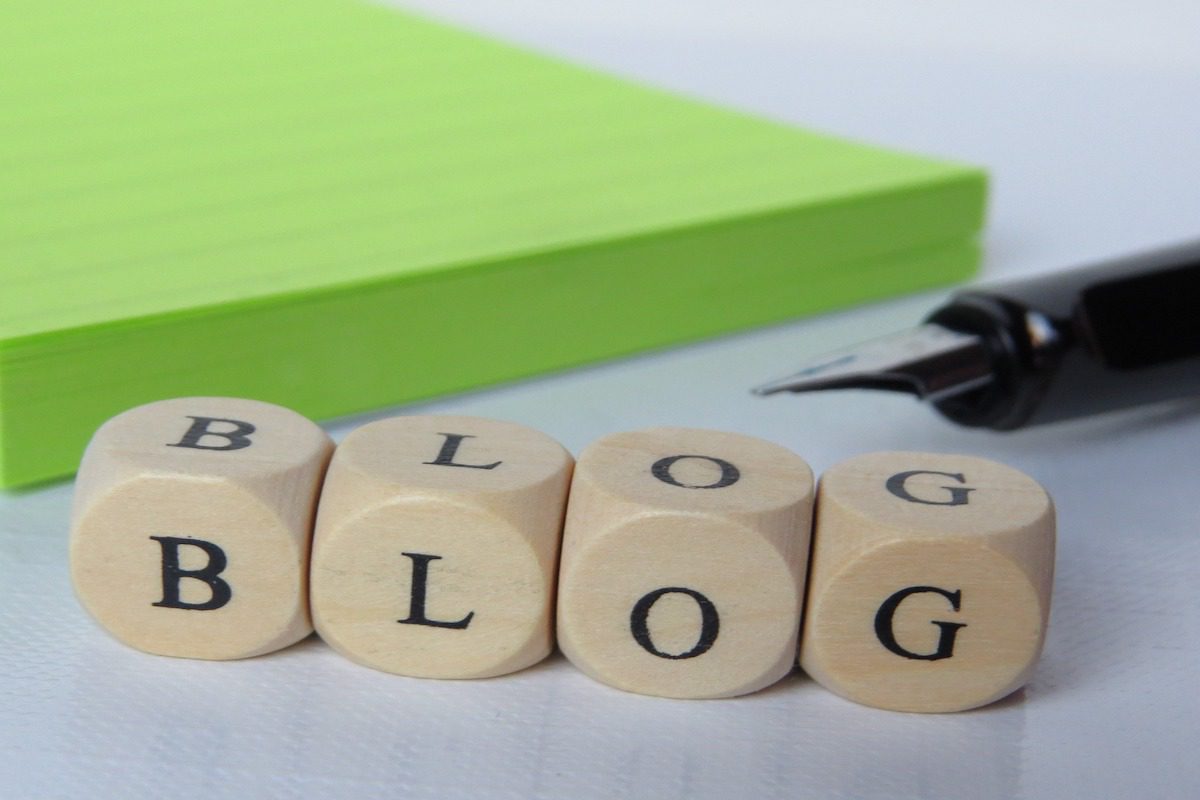 Dices on a white table displaying the word blog.