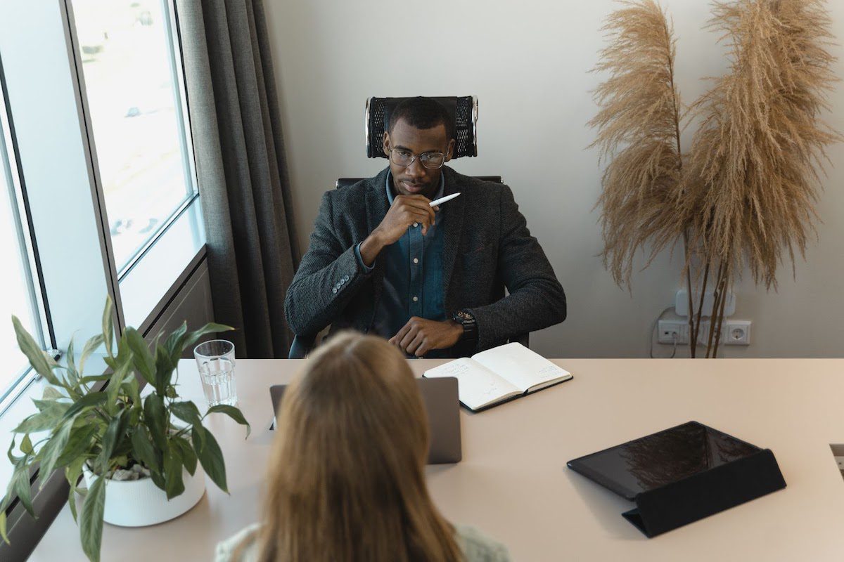 A man interviewing a woman at a desk