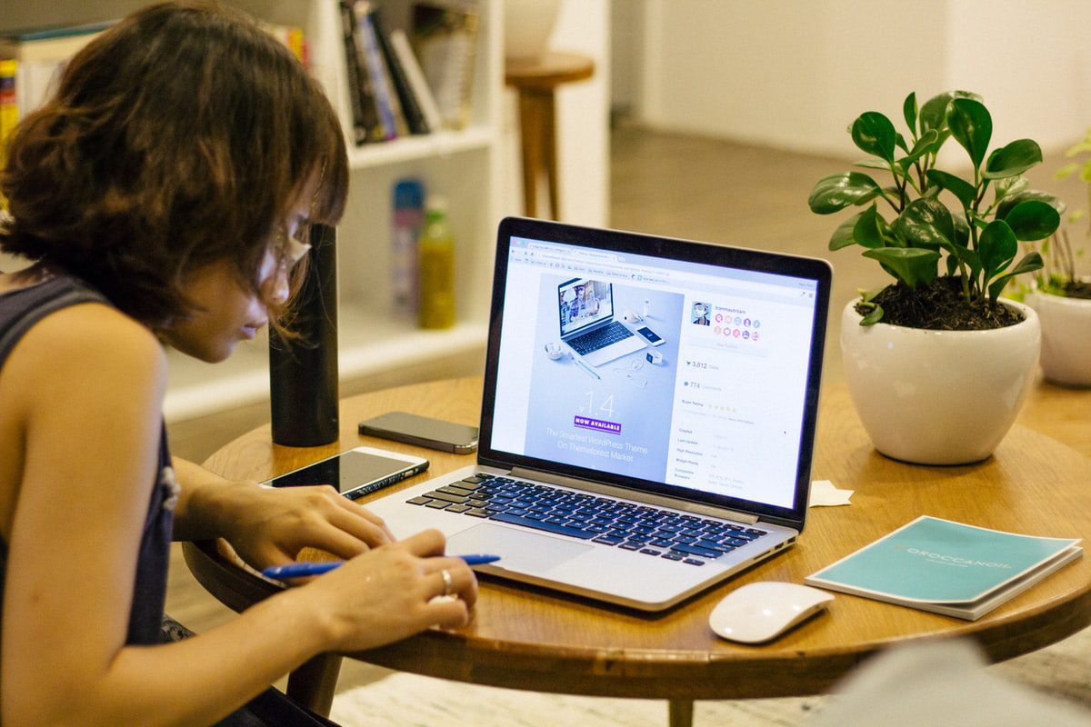 A woman browsing through video lectures on her laptop screen