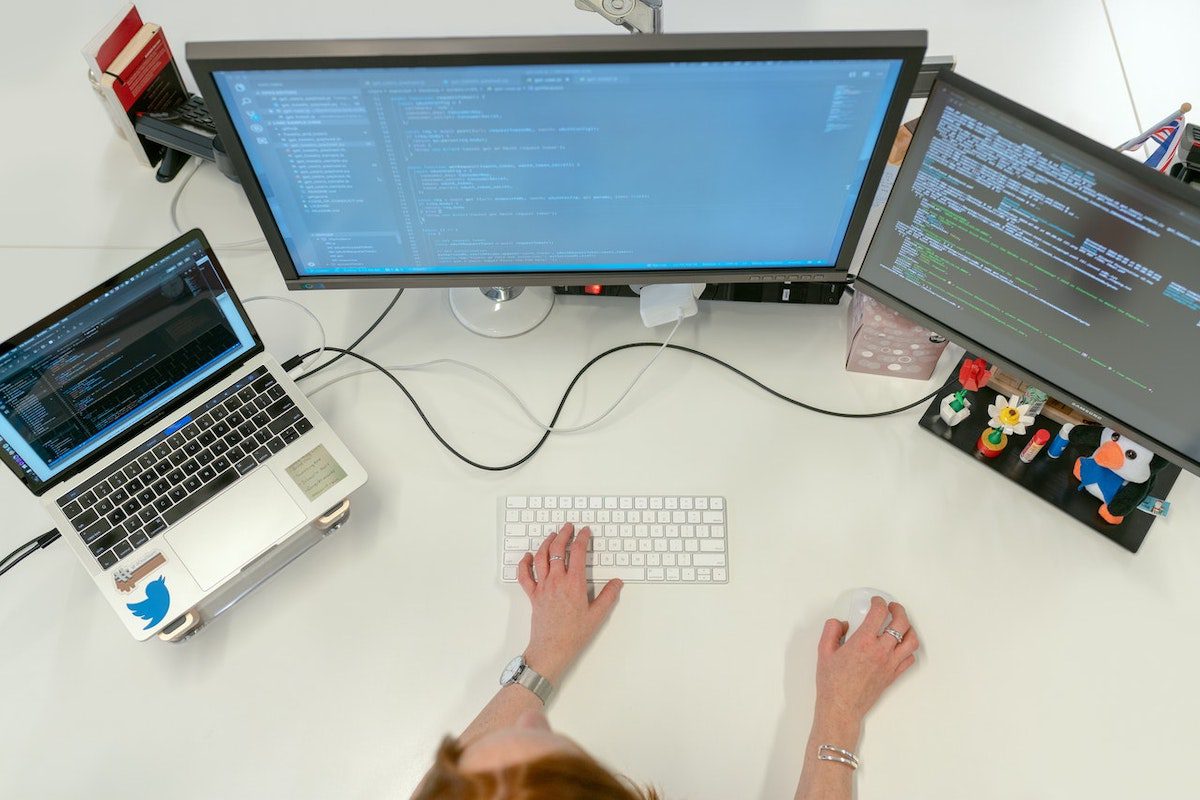 Female software engineer coding on computers