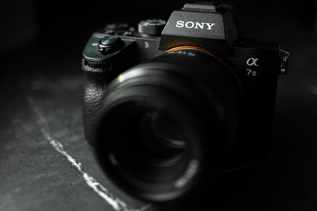 A black Sony DSLR camera with no lens cap facing forward. Sony Benefits