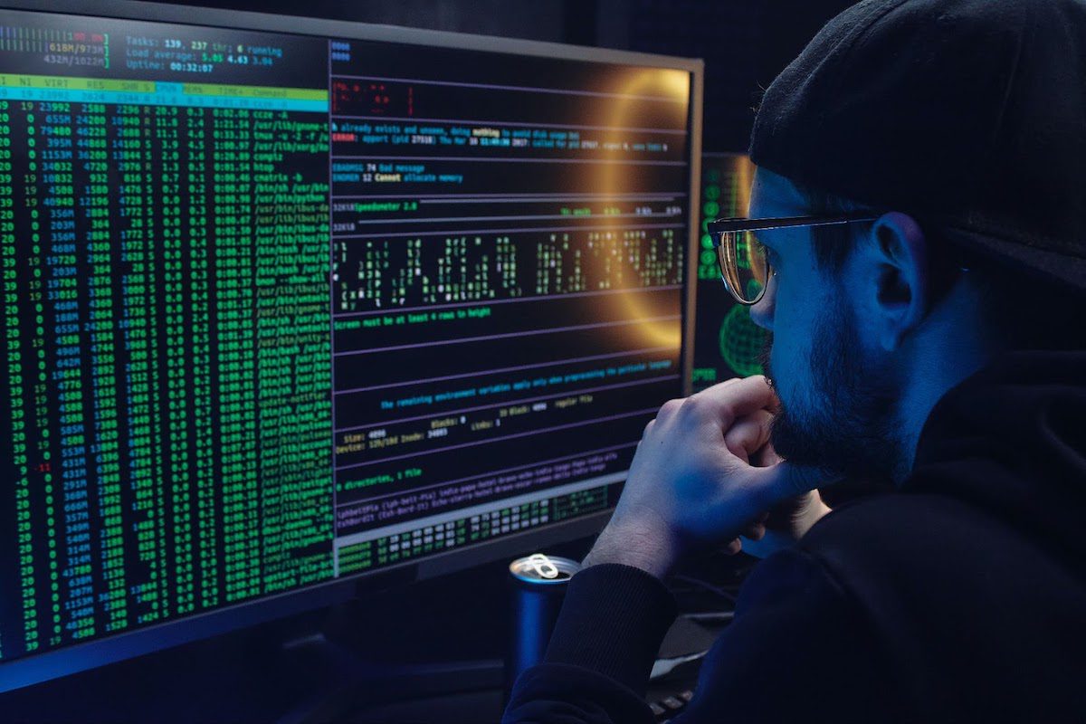 Man looking at a desktop computer with coding. 