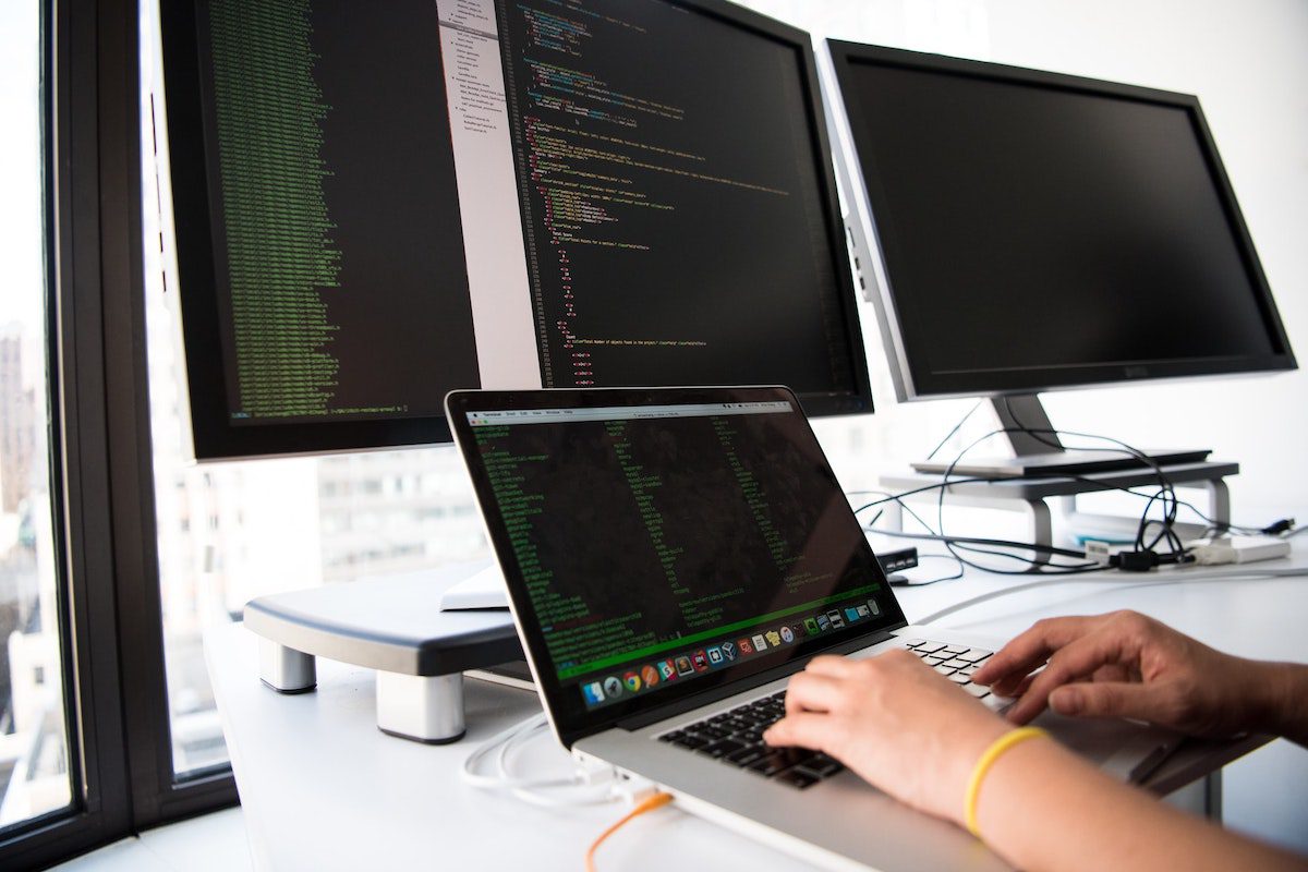 Close up coding shot of someone working on a single project on their desktop and laptop computers. Online C# Compiler