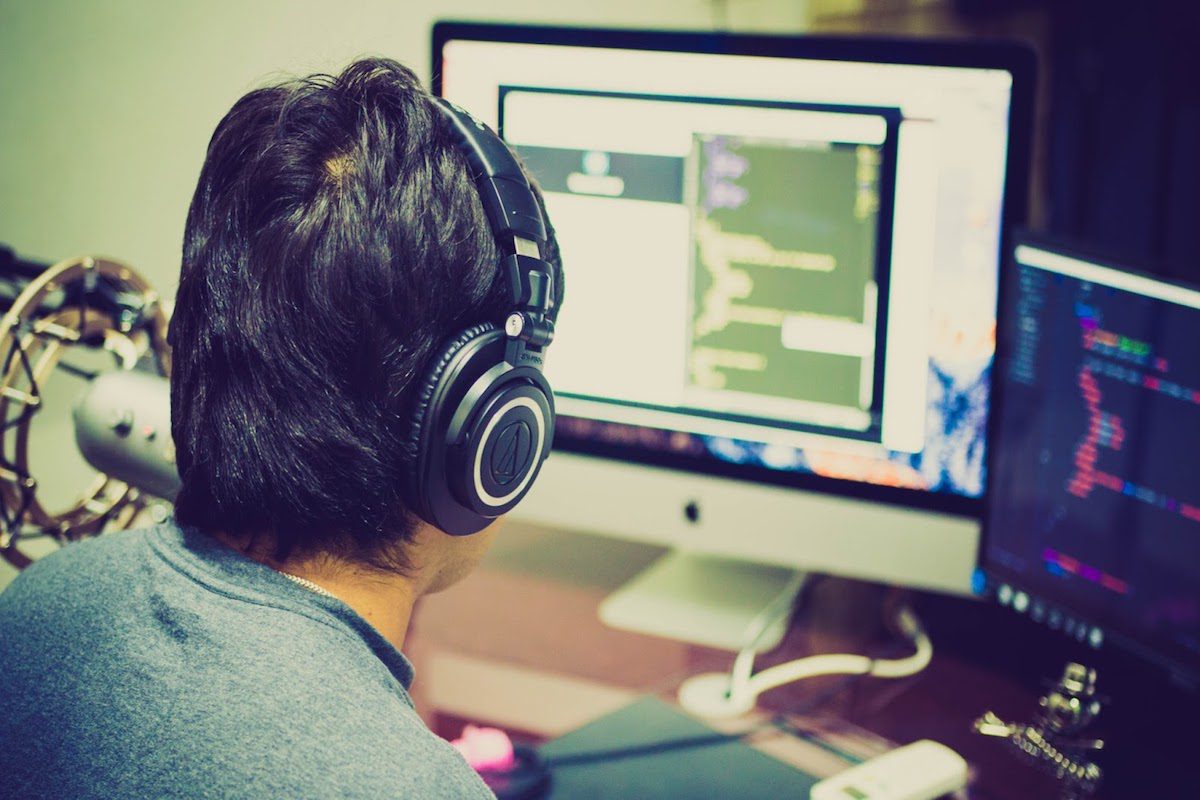 Man wearing headphones in front of a computer