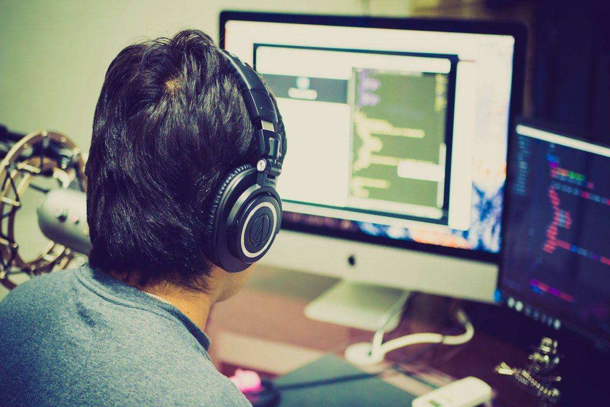 A computer programmer types code into computer monitors