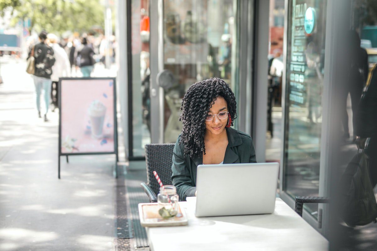 A woman sitting outside a café working on her laptop. Is C Hard to Learn?