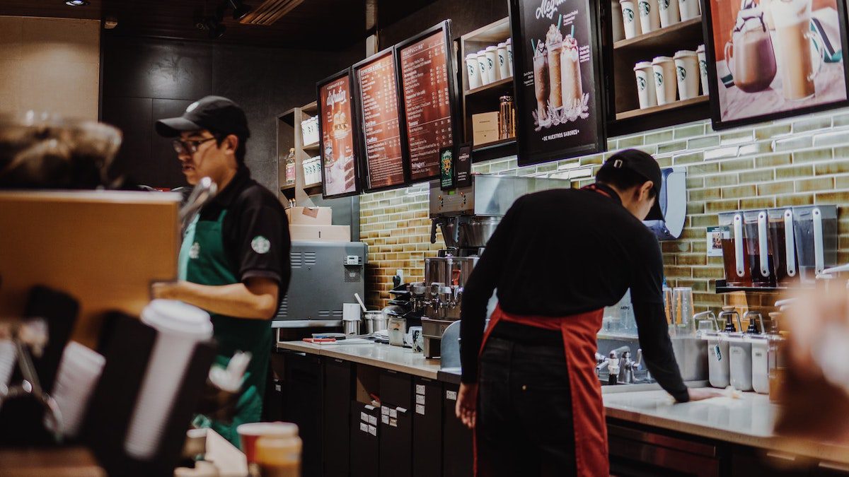 Two Starbucks employees working and serving customers. The Biggest Companies to Work for in Los Angeles