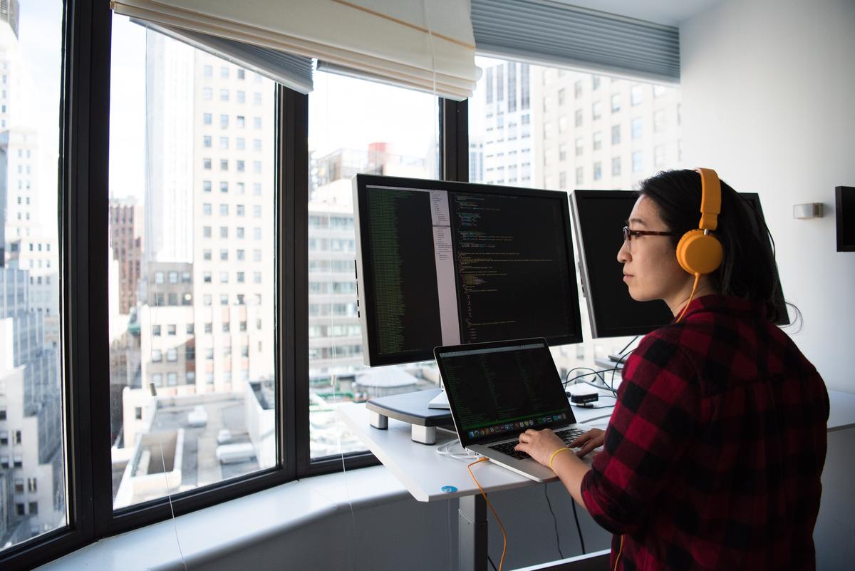 A coding professional at work on their laptop.