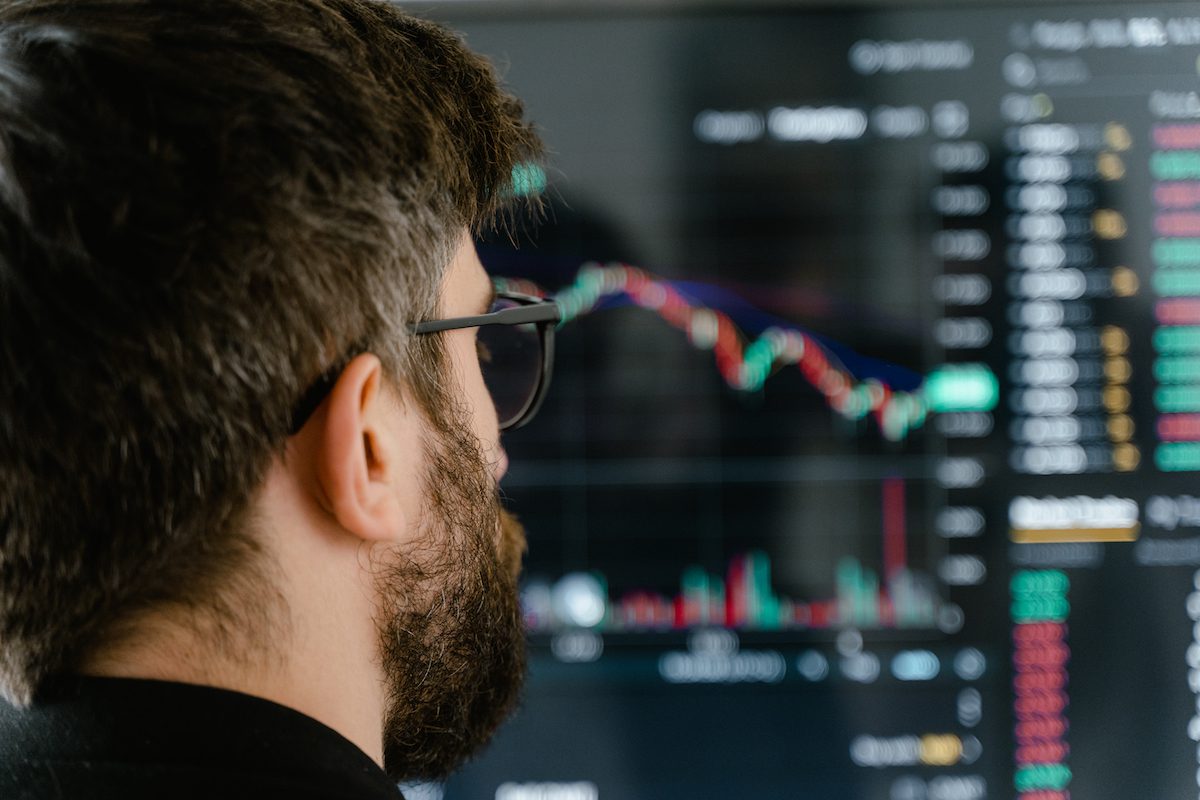 A man with glasses analyzing data on a screen