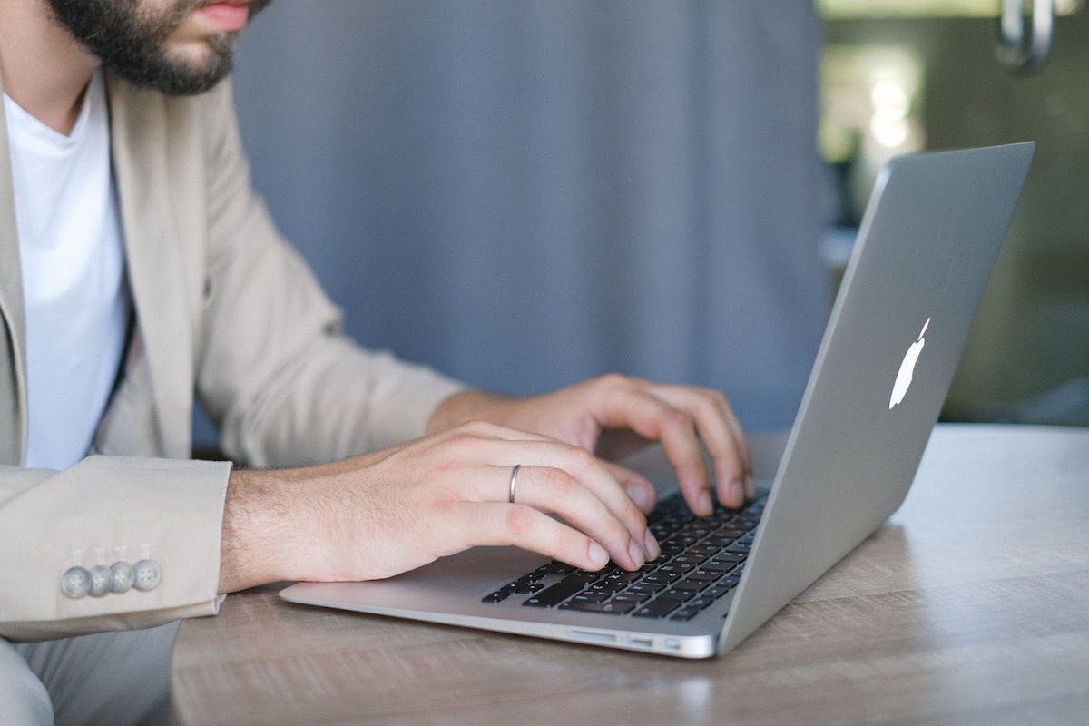 A programmer uses his laptop to complete a commit message during the commit stage to describe changes to the original project in a Git repository