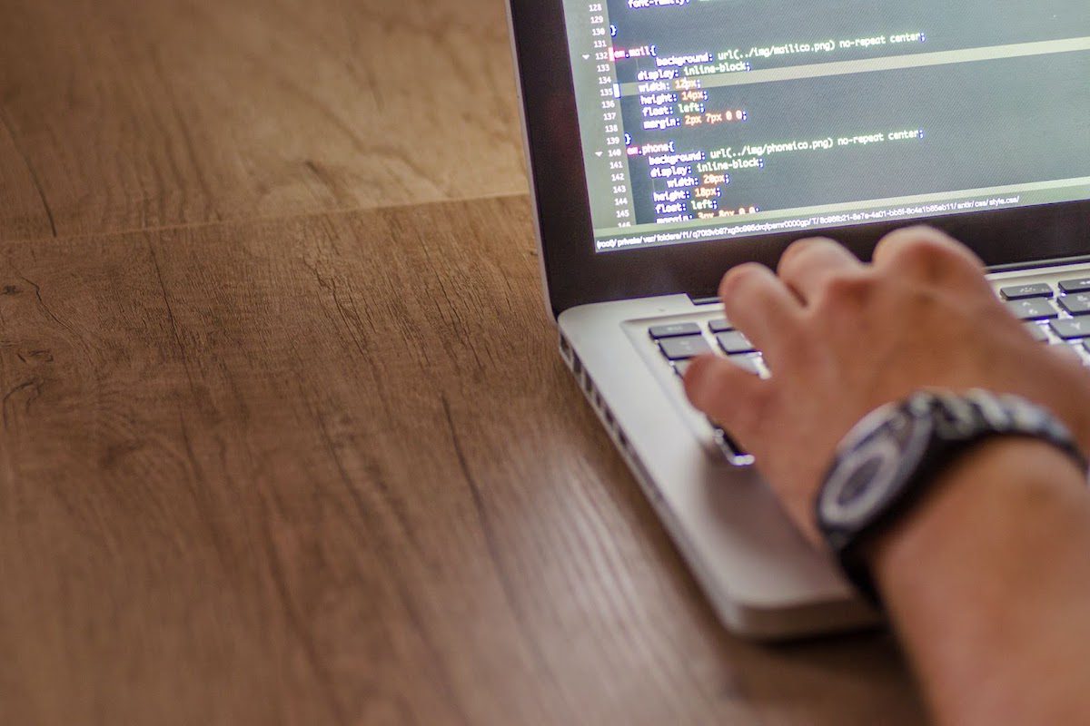 A person typing code on a laptop. 