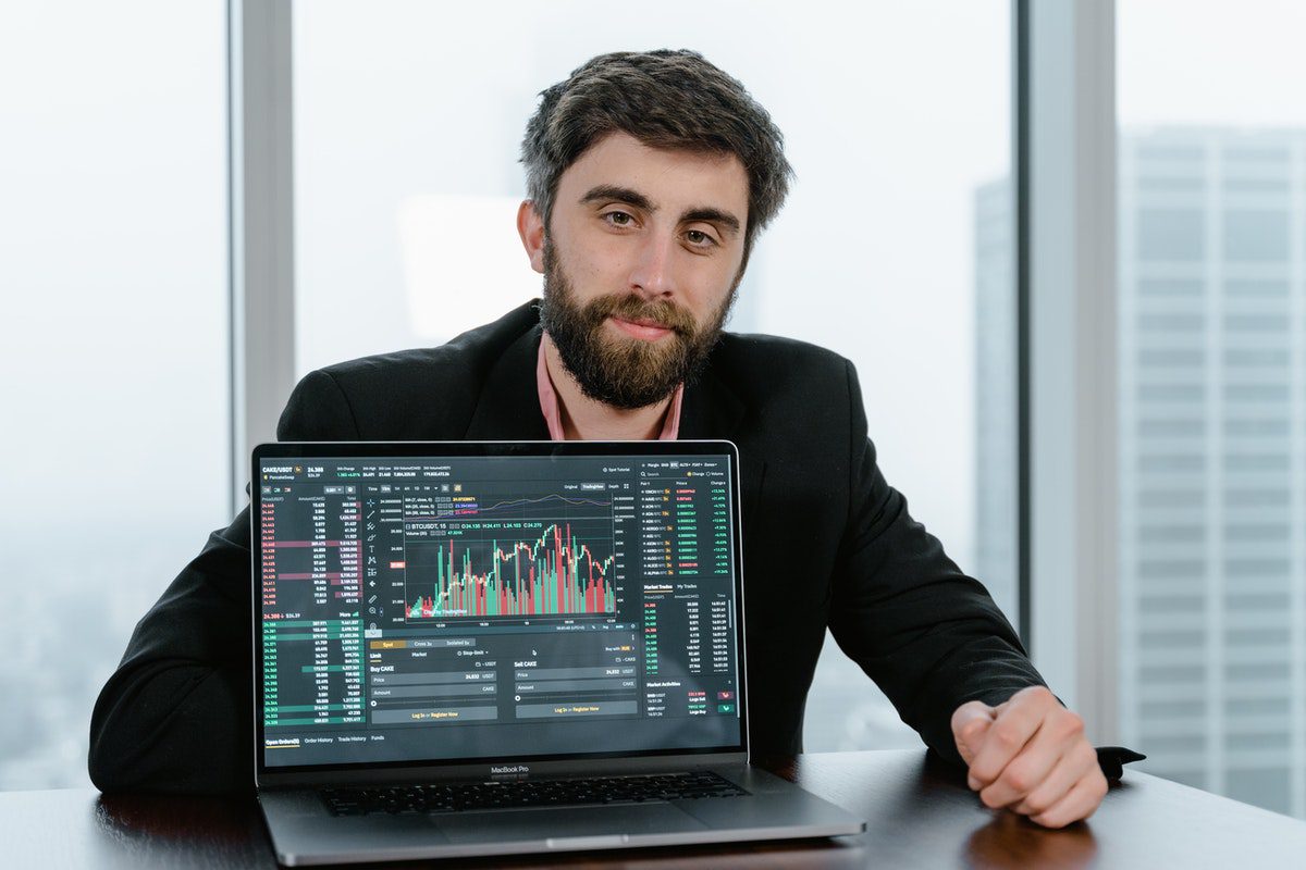 A man in black presenting his report on his laptop. Data Science Remote Jobs