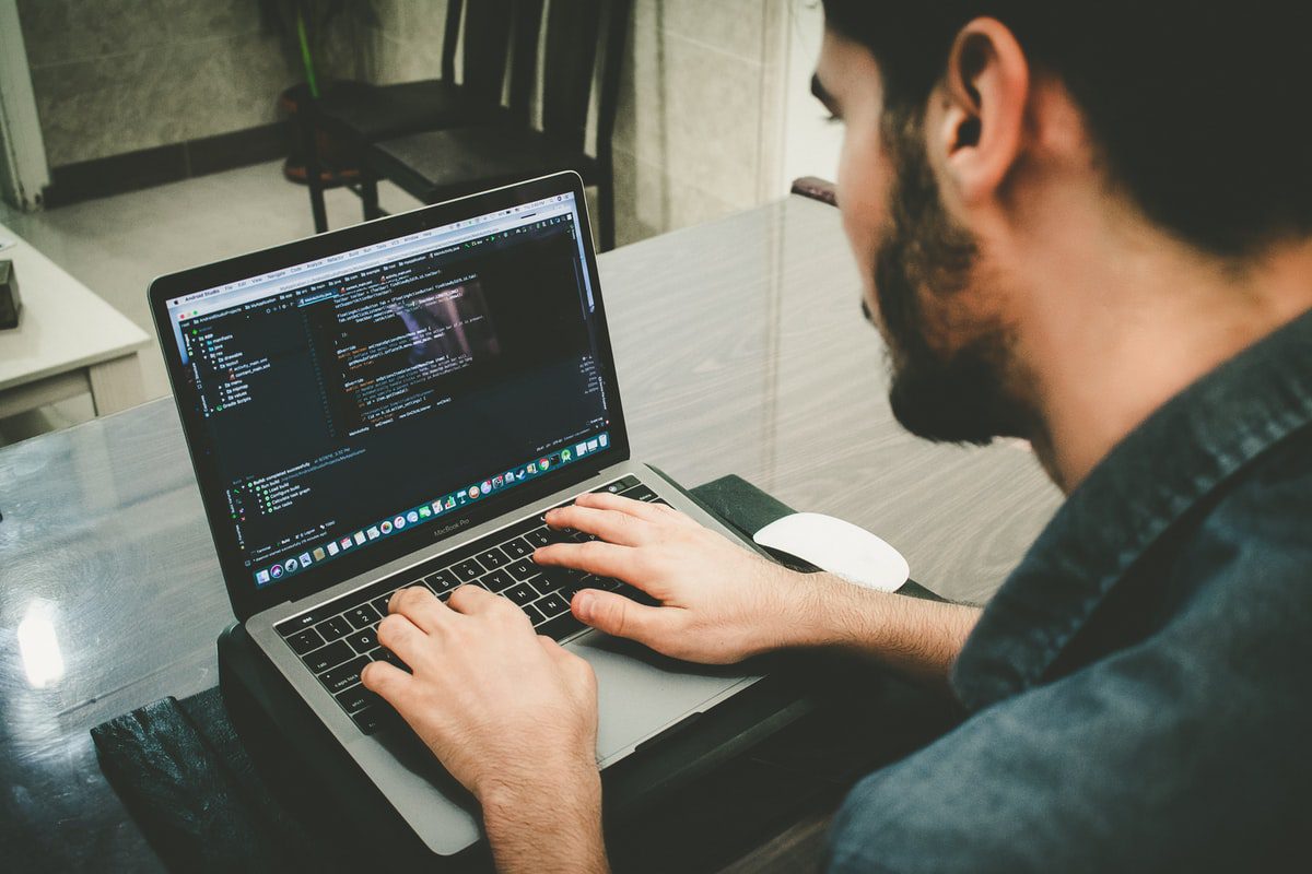A man coding on a laptop