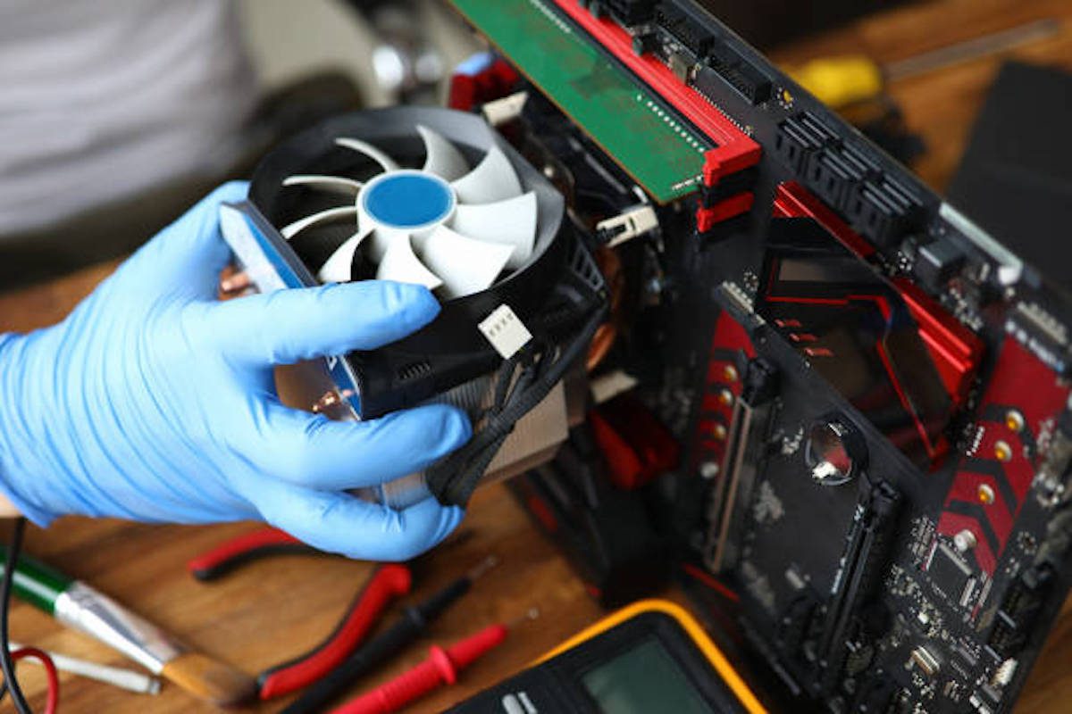 A person wearing blue gloves while assembling a customized PC. 