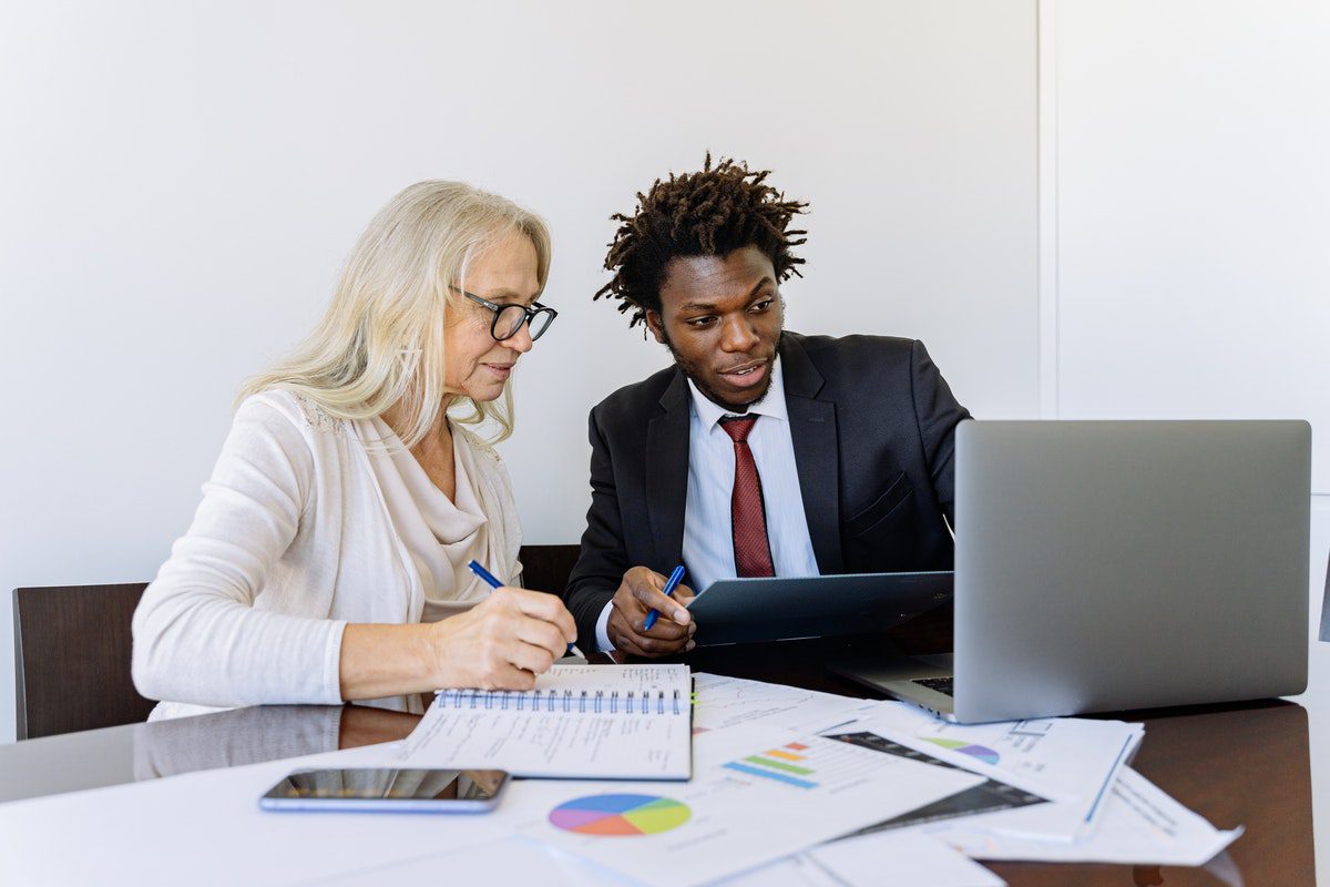 Two people sitting at a table with a laptop in front of them. How To Get An Internship At Spacex