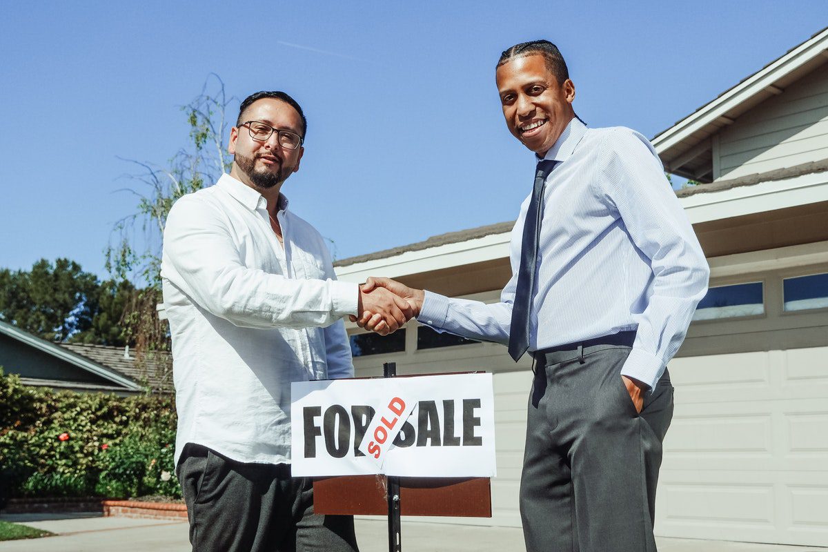 Two men shaking hands in front of a sold house. Jobs That Require No Experience But Pay Well