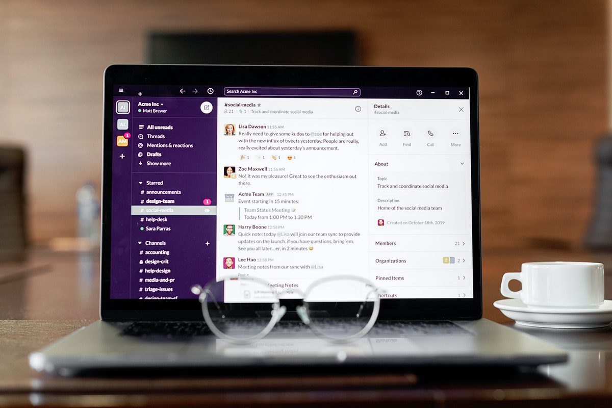 A pair of glasses on top of a laptop, with the dashboard of the Slack app on the laptop screen. Slack Channels for Mobile Developers