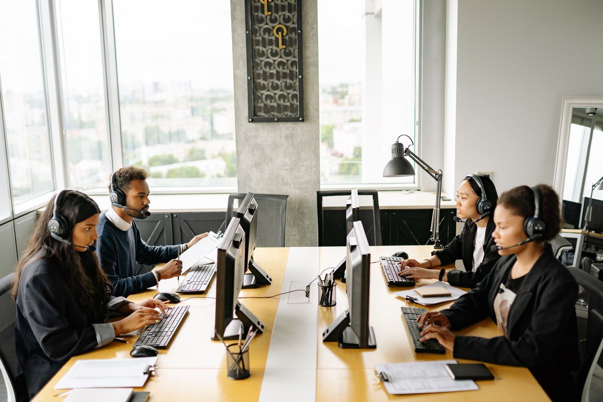 network of IT professionals working in a call center with headsets. How To Get A Job In Networking