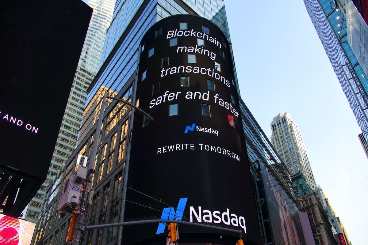 An advertisement on the side of a building that reads “blockchain making transactions safer and faster.