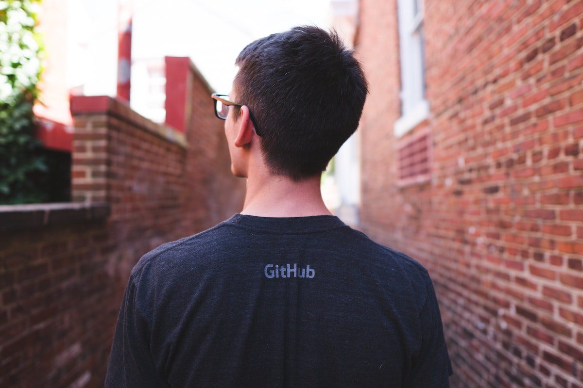 A photo of the back of a man in glasses wearing Github shirt. Who Uses Github?