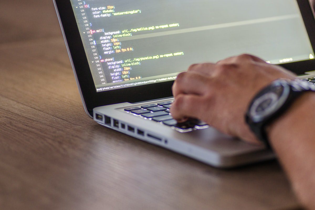 A man writing lines of code on a laptop. Who Uses Html?