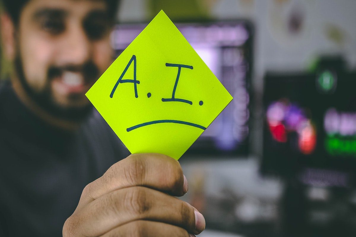 A man holding a sticky note with “AI” written on it.  Jobs That Use Machine Learning