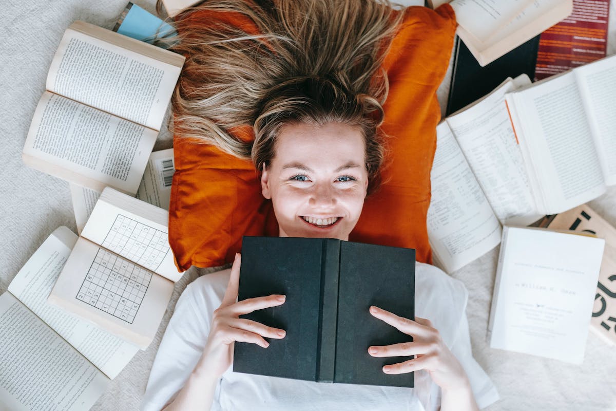 Woman psychology student happily studying lying with books on the floor. Jobs That Use Psychology