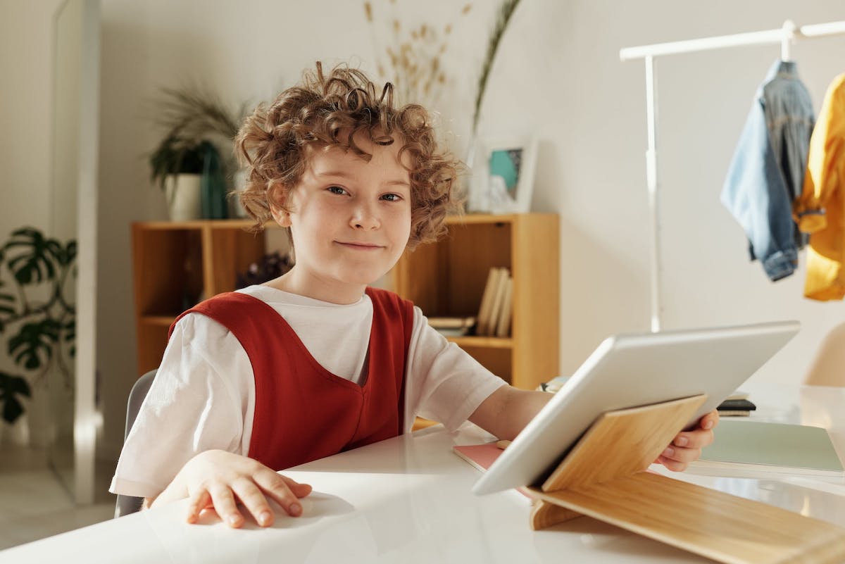 A child smiling and using a digital tablet to learn about animation techniques.  Computer Animation For Kids