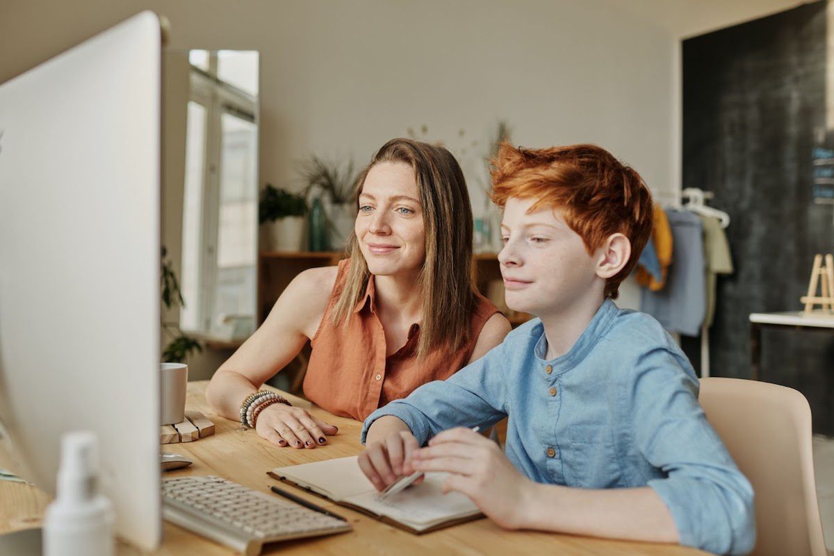 A young boy with his mother in front of a computer monitor. Machine Learning For Kids