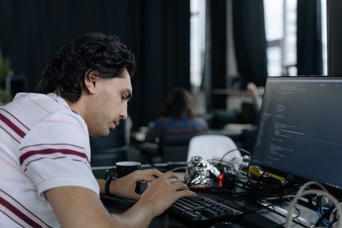 A web developer is typing on a keyboard in front of a computer monitor. Companies That Use Django