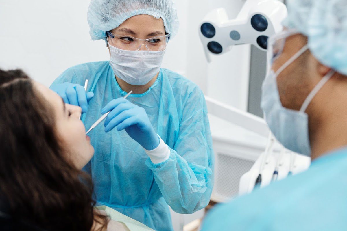 a dentist and dental hygienist carrying out an oral inspection on a patient using some tools A Day in the Life of a Dental Hygienist