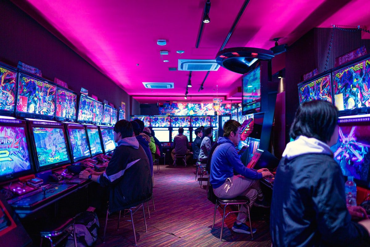 People playing video games in an arcade. A Day In The Life Of A Videogame Designer