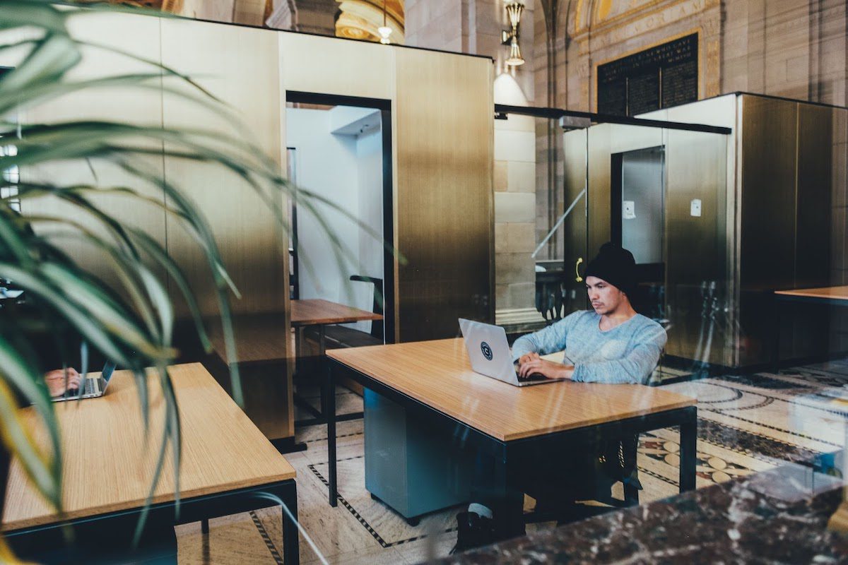 A person sitting at a desk while typing on their computer.