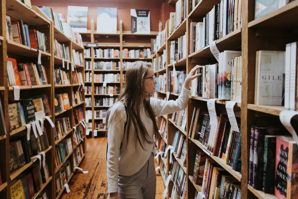 A law school applicant looking through books in a library.