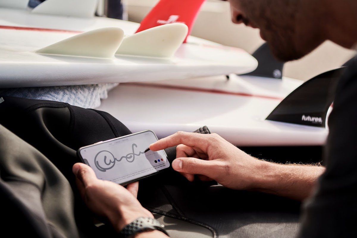 A man signs his electronic signature onto a smartphone