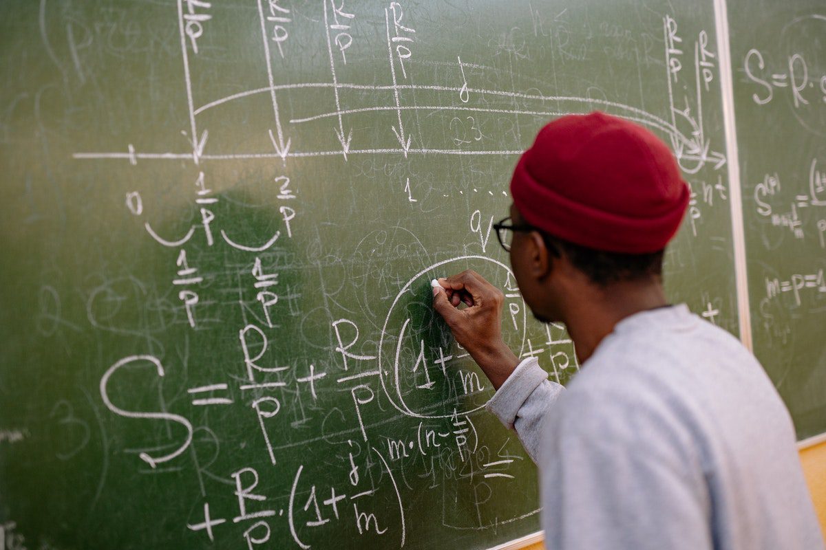 A boy writing on a blackboard. Best Universities In Indiana