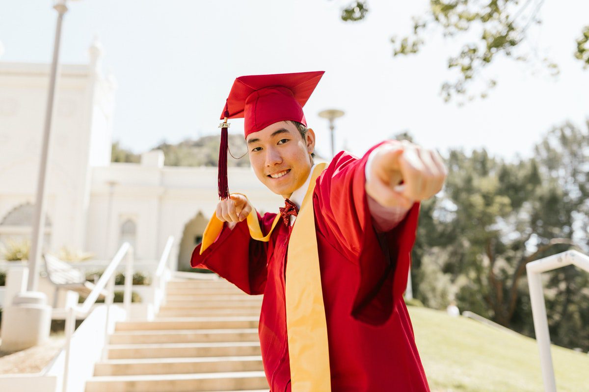 Person in red university gown celebrating successful life at college or university. Best Universities In Pennsylvania