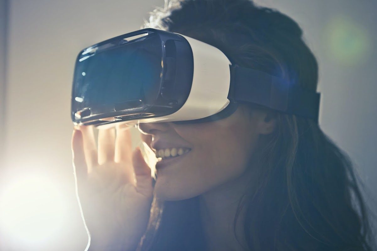 A lady wearing VR goggles and smiling