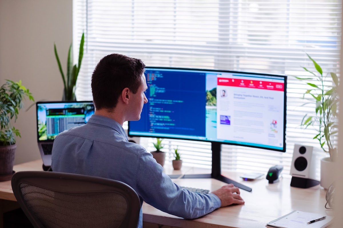 A man working on two computer screens.