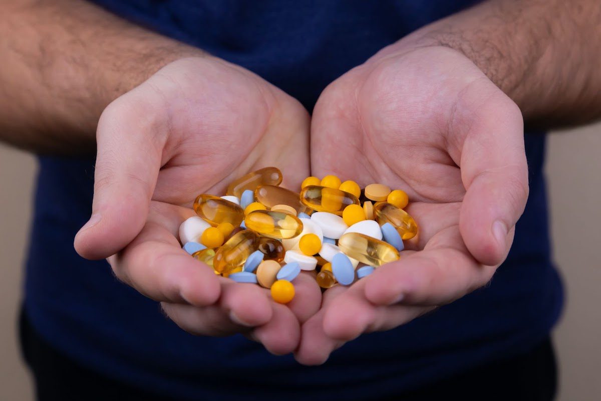 A man holding a bunch of pharmaceutical pills in his hands How to Get Into Pharmacy School