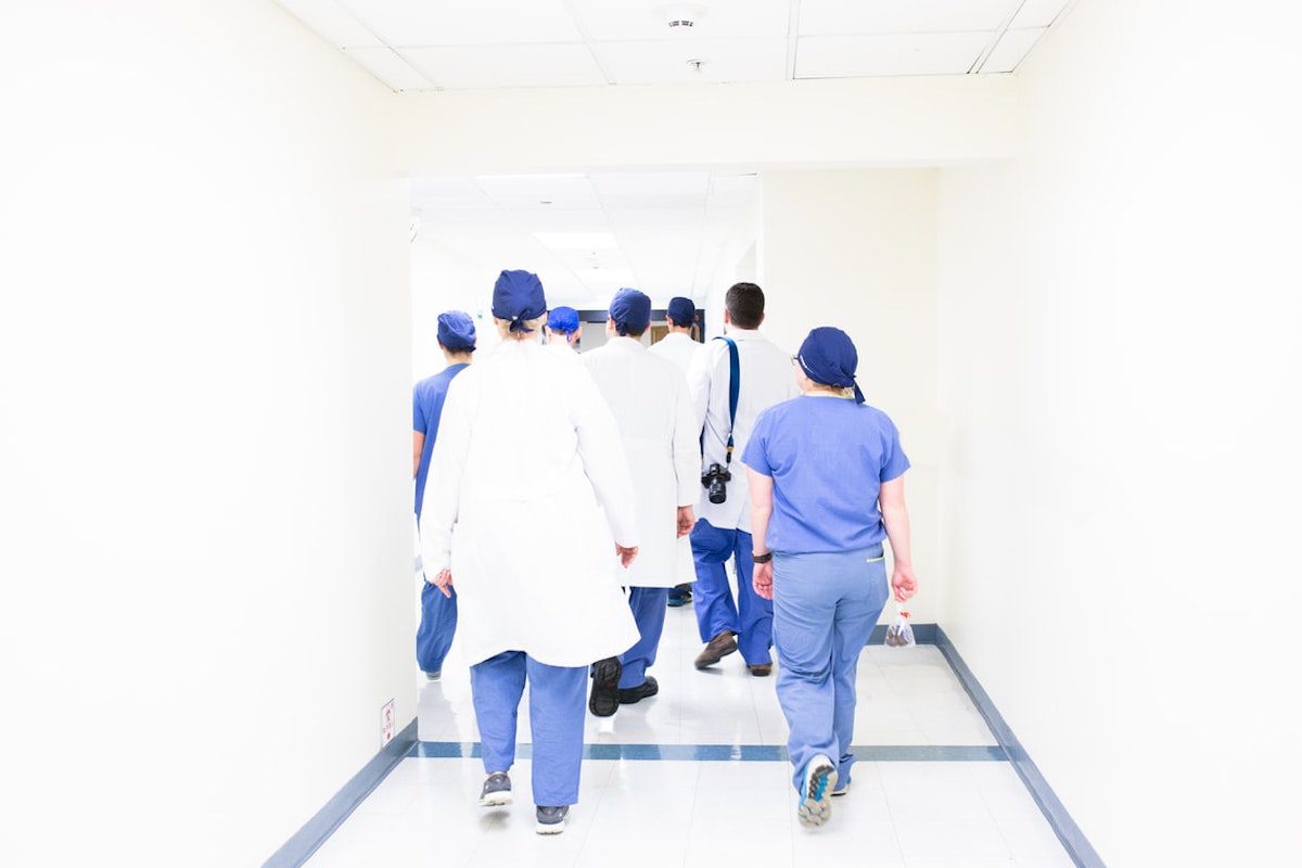 A group of medical doctors and nurses wearing scrubs walking through a hallway  How To Get Into Medical School