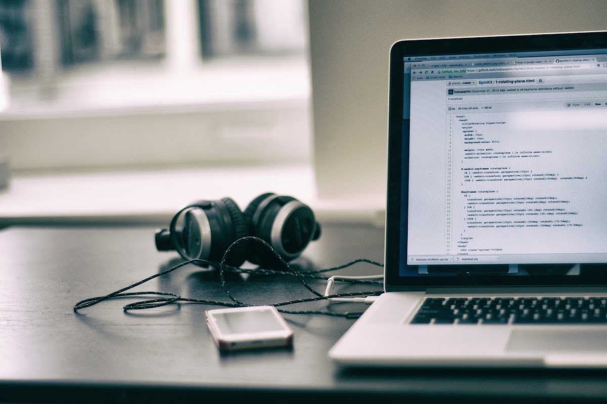 A laptop, headphone, and smartphone on a desk. How to Get a Job in SQL Development