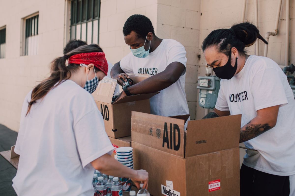 Three people pack aid boxes for a social program.