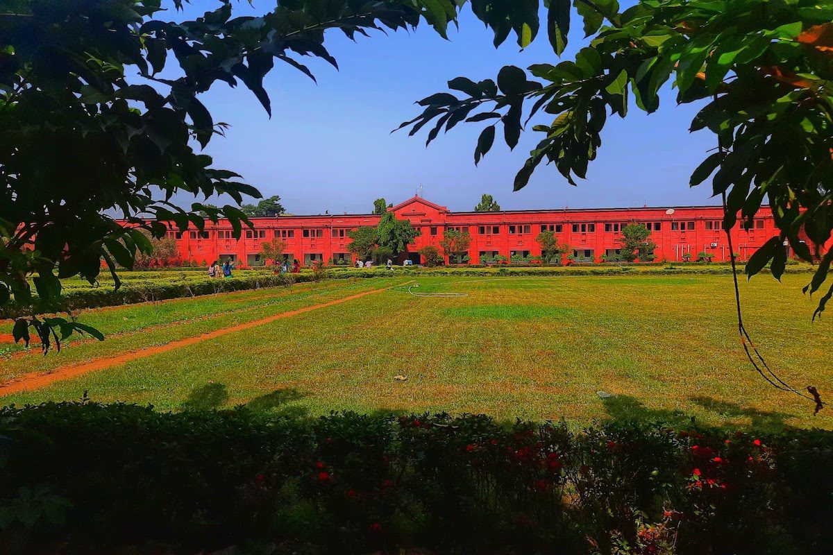 Indian University building at a distance with a large green field
