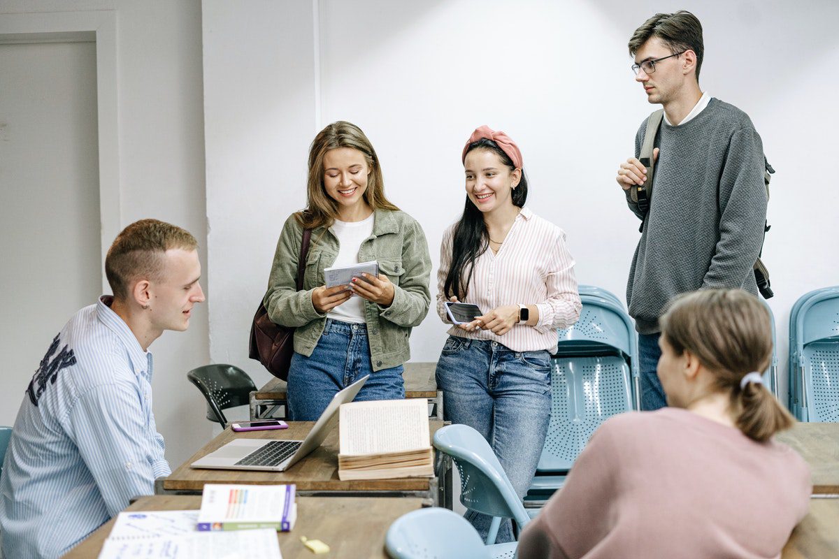 People in a room talking and working.