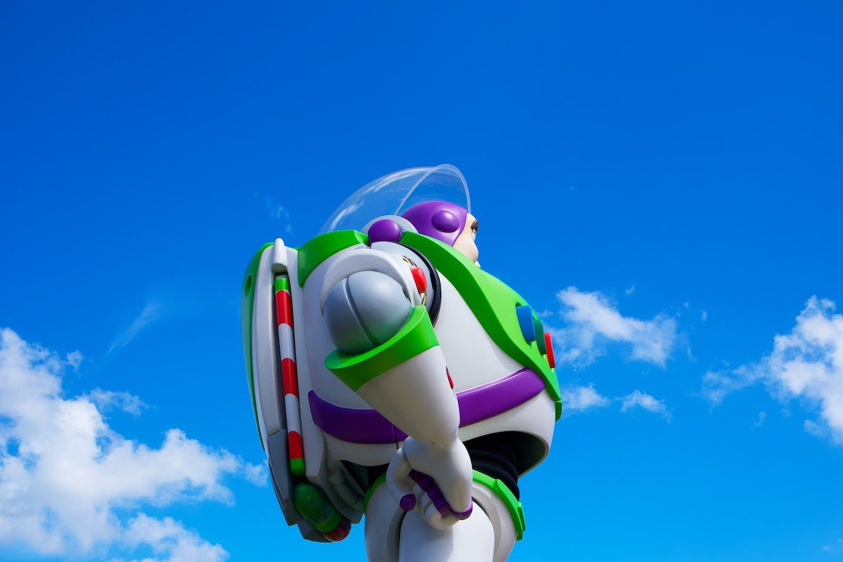 Buzz Lightyear in front of a sky with clouds looking into the distance