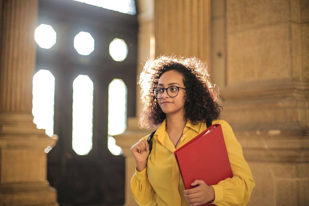 A student holding a red binder. The Best Universities in Latin America