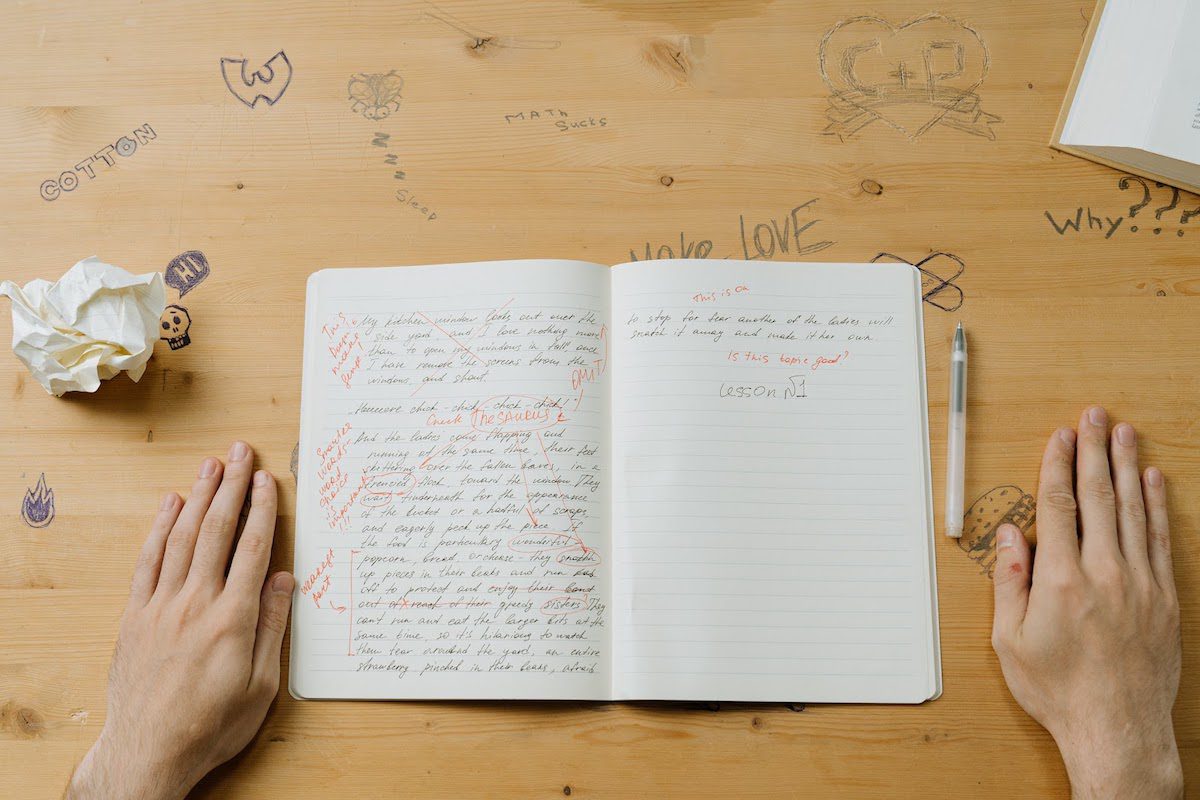 A notebook lies open on a wooden table, filled with handwritten text. How to Write an Abstract