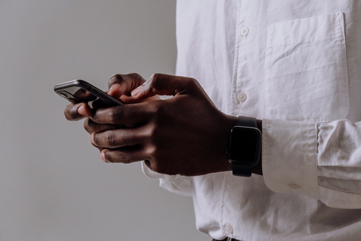  A man wearing a white shirt and a watch using his smartphone. Best Job Apps