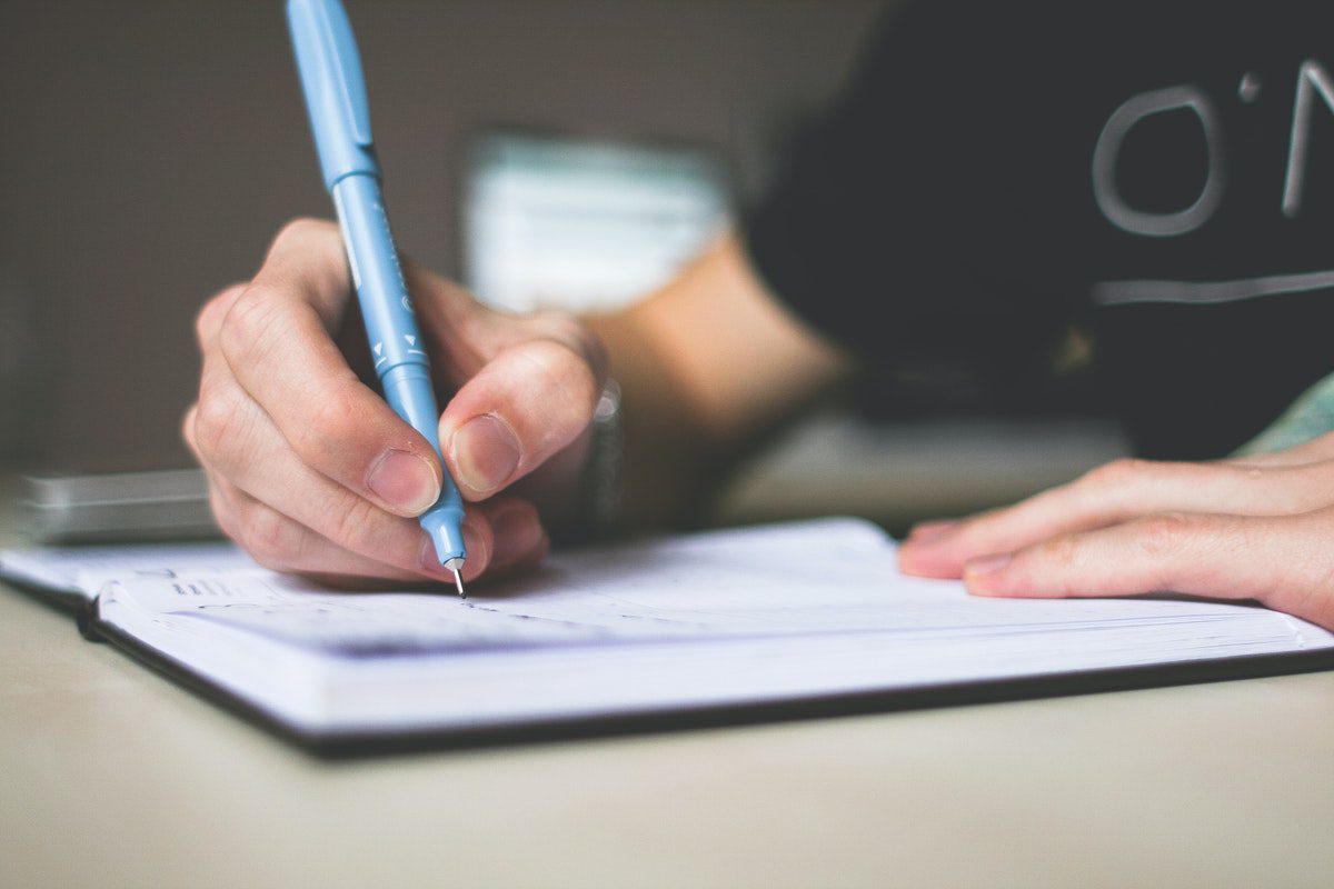 A person writing ideas with a pen and notebook